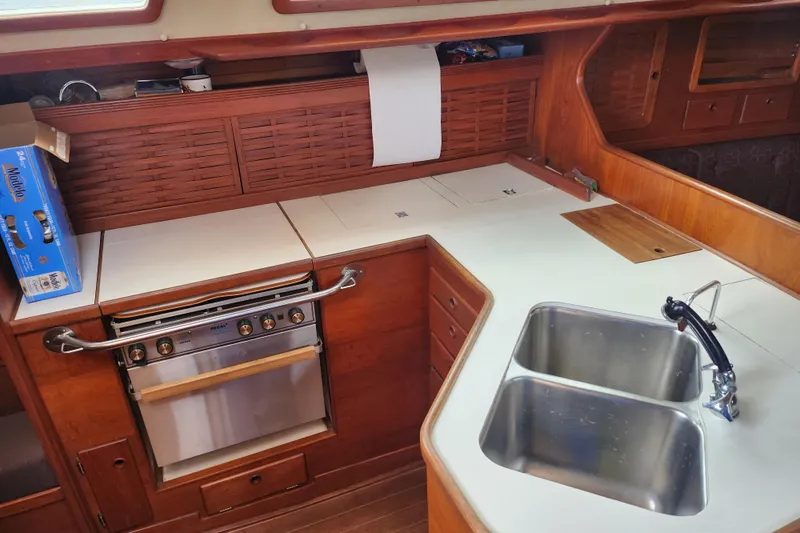 Isola Bella Yacht Photos Pics 1988 Sabre 42 yacht kitchen with wood cabinetry, dual sink, and stove.