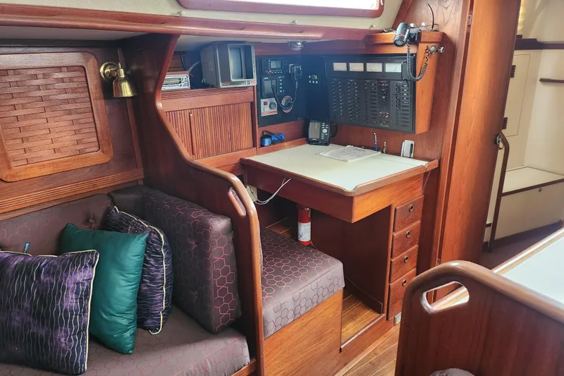 Isola Bella Yacht Photos Pics Interior of 1988 Sabre 42 sailboat with navigation station and cozy seating area.
