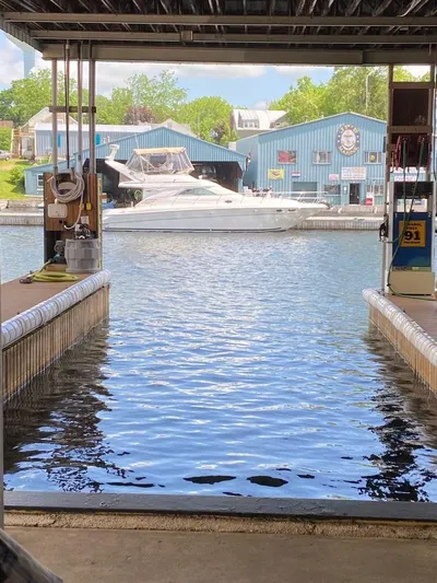  Yacht Photos Pics 2000 Sea Ray 400 Sedan Bridge docked at a marina with blue buildings in the background.