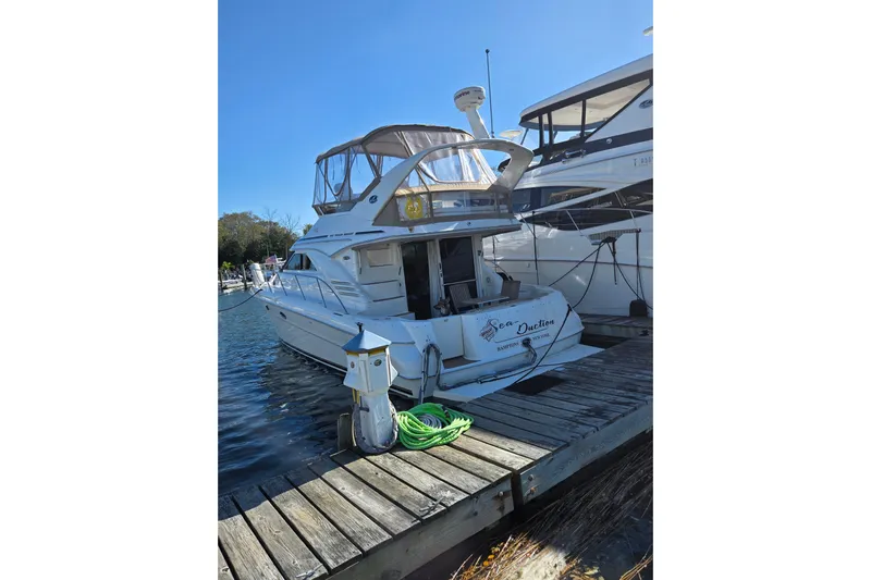 Yacht Photos Pics 2000 Sea Ray 400 Sedan Bridge docked at marina, clear sky, green hose on pier.