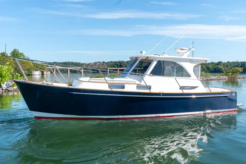  Yacht Photos Pics 2002 Legacy 34 Express boat on calm water, clear sky background.
