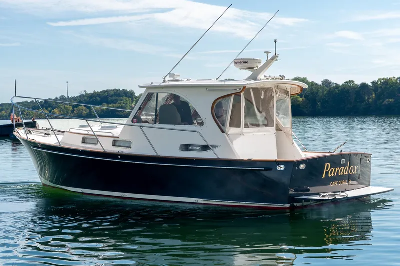  Yacht Photos Pics 2002 Legacy 34 Express boat named "Paradox" on a calm lake.
