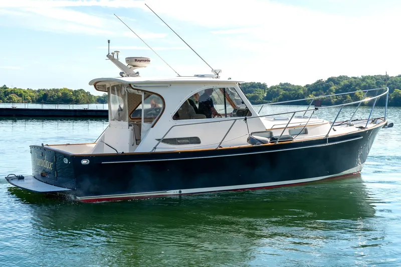  Yacht Photos Pics 2002 Legacy 34 Express boat on calm water, side view.
