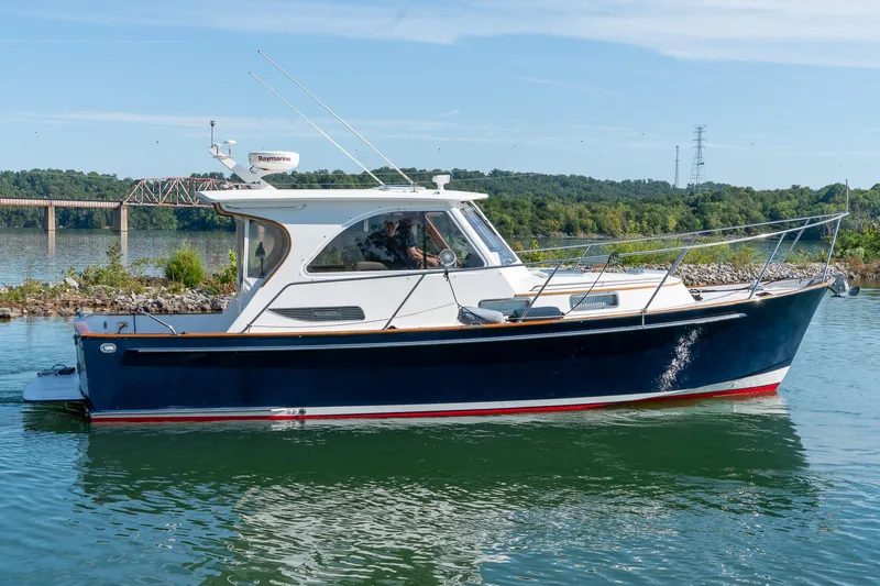  Yacht Photos Pics 2002 Legacy 34 Express boat on calm water with scenic background.