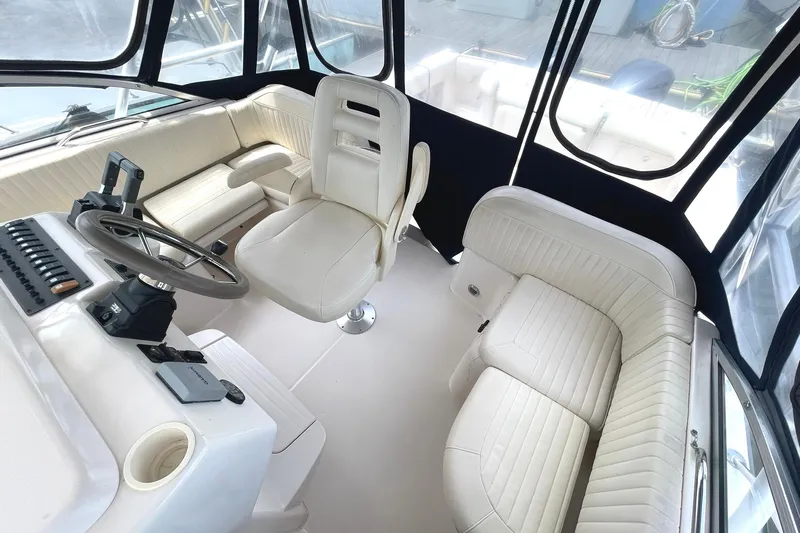  Yacht Photos Pics 2003 Grady-White Express 330 boat interior with white seating and steering console.
