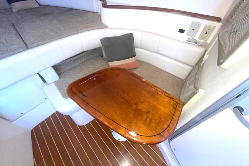  Yacht Photos Pics 2003 Grady-White Express 330 cabin interior with wooden table and cushioned seating.