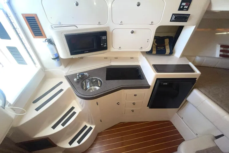  Yacht Photos Pics 2003 Grady-White Express 330 boat interior with kitchenette, microwave, sink, and compact fridge.