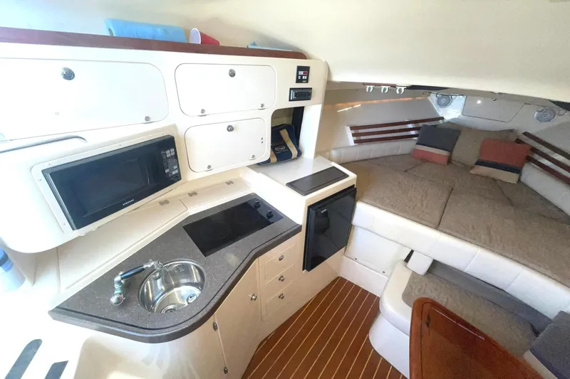  Yacht Photos Pics 2003 Grady-White Express 330 cabin interior with kitchenette and cozy seating area.