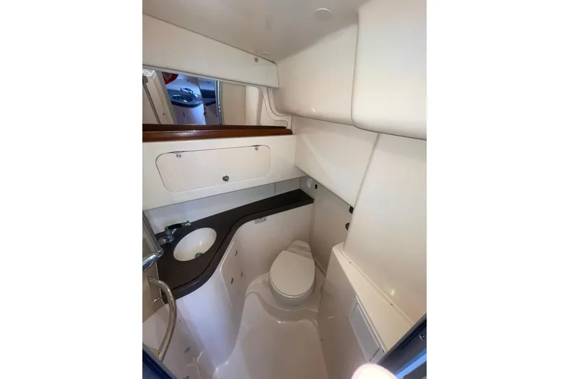  Yacht Photos Pics Compact bathroom in 2003 Grady-White Express 330 boat, featuring sink, toilet, and storage.