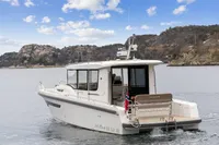 2021 Nimbus C11 boat cruising on a scenic lake with rocky hills in the background.