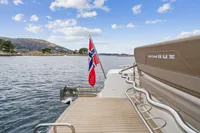 Nimbus C11 boat with Norwegian flag on scenic water, 2021 model.