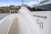 2021 Nimbus C11 boat with sleek design and wooden deck, docked by the water.