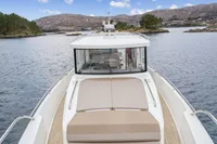 Nimbus C11 2021 boat cruising in scenic lake with mountainous backdrop.