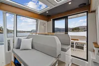 Interior of 2021 Nimbus C11 boat with scenic water view through large windows.