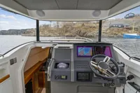Modern Nimbus C11 boat cockpit with advanced navigation system, steering wheel, and scenic water view.