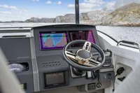 Boat dashboard of 2021 Nimbus C11 with navigation screens and steering wheel.