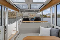 Modern interior of 2021 Nimbus C11 boat with panoramic windows and comfortable seating.