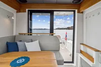 Interior of 2021 Nimbus C11 boat with cozy seating and scenic ocean view.