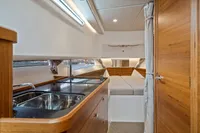2021 Nimbus C11 yacht interior with modern kitchen and cozy sleeping area.