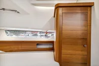 Interior of 2021 Nimbus C11 boat with wooden cabinet and window view.