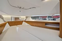 Interior cabin of 2021 Nimbus C11 boat with wood accents and large windows.