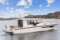 Nimbus C11 2021 boat cruising on a scenic lake with rocky hills in the background.