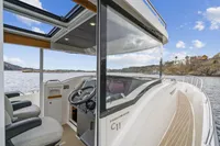 2021 Nimbus C11 boat interior with steering wheel, seats, and scenic water view.