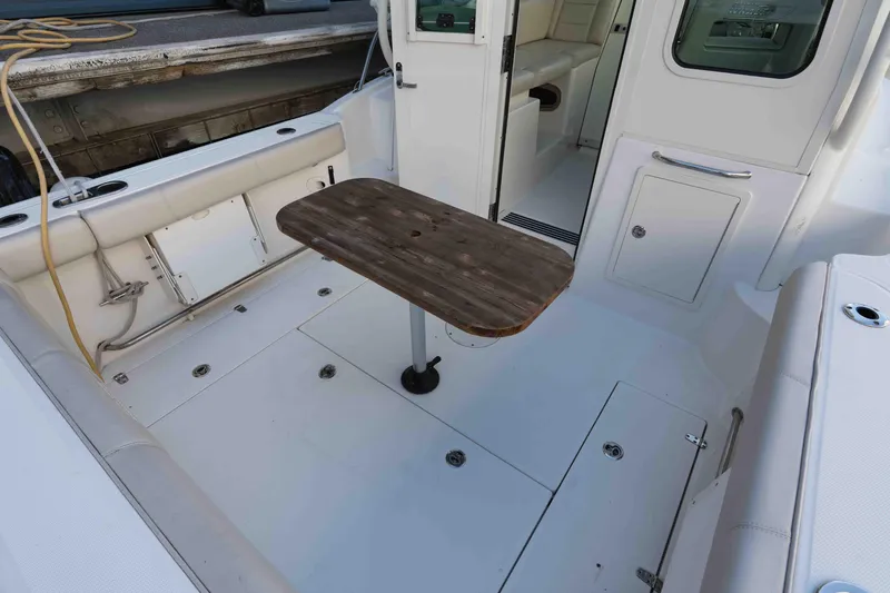  Yacht Photos Pics 2016 Boston Whaler 285 Conquest Pilothouse cockpit with wooden table and seating area.