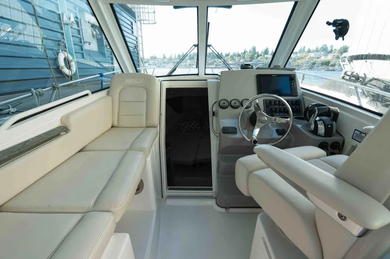  Yacht Photos Pics 2016 Boston Whaler 285 Conquest Pilothouse interior with helm and seating area.
