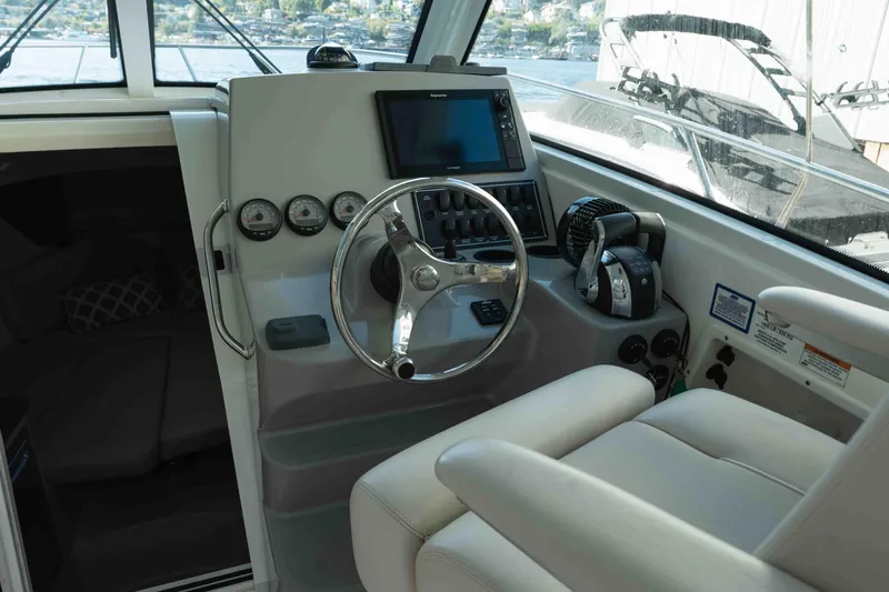  Yacht Photos Pics 2016 Boston Whaler 285 Conquest Pilothouse helm with steering wheel and navigation controls.