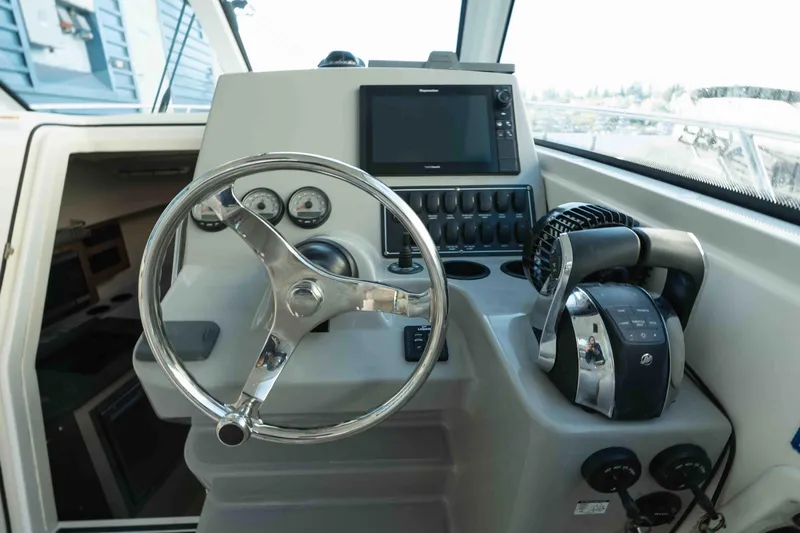  Yacht Photos Pics 2016 Boston Whaler 285 Conquest Pilothouse helm with steering wheel and controls.