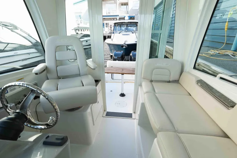  Yacht Photos Pics Interior of 2016 Boston Whaler 285 Conquest Pilothouse with seating and steering wheel.