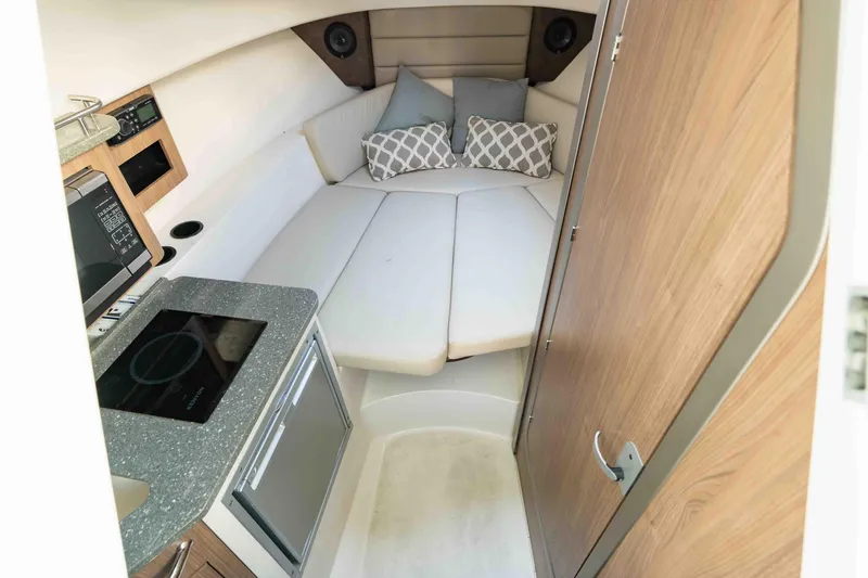  Yacht Photos Pics 2016 Boston Whaler 285 Conquest Pilothouse interior with kitchenette and cozy sleeping area.