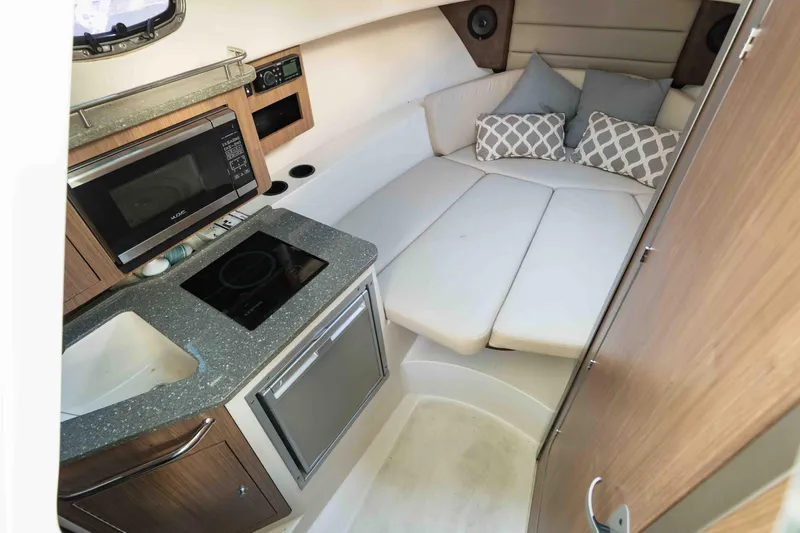  Yacht Photos Pics 2016 Boston Whaler 285 Conquest Pilothouse interior with kitchenette and cozy seating area.