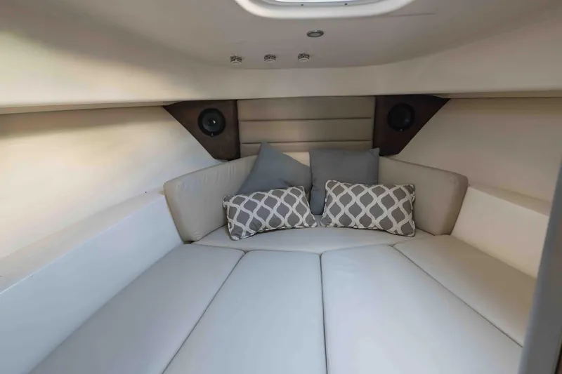  Yacht Photos Pics 2016 Boston Whaler 285 Conquest Pilothouse cabin with cushioned seating and decorative pillows.