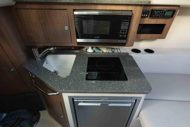  Yacht Photos Pics 2016 Boston Whaler 285 Conquest Pilothouse kitchen with sink, microwave, and stove.