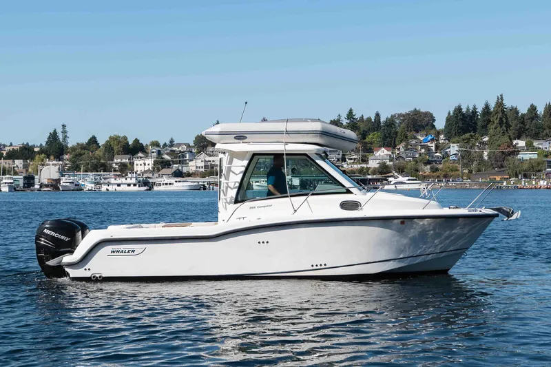  Yacht Photos Pics 2016 Boston Whaler 285 Conquest Pilothouse on calm water, scenic background.