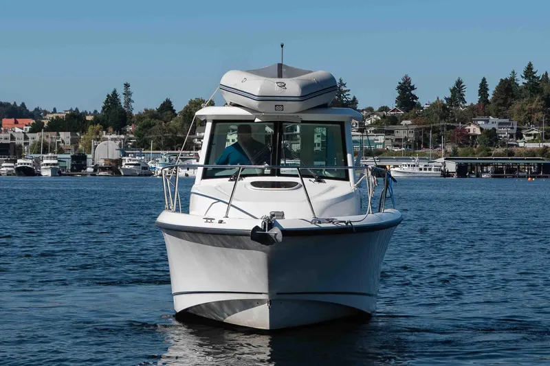  Yacht Photos Pics 2016 Boston Whaler 285 Conquest Pilothouse on water, with scenic marina background.