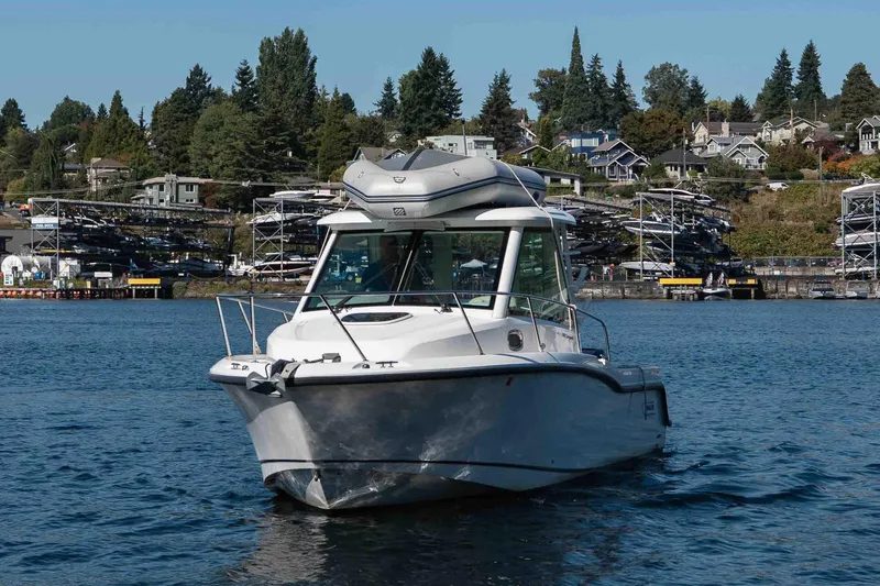 Yacht Photos Pics 2016 Boston Whaler 285 Conquest Pilothouse on water near marina and houses.