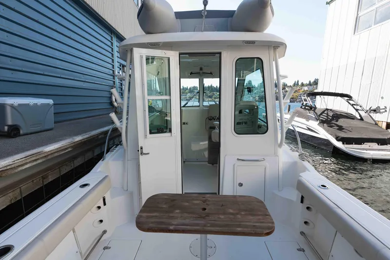  Yacht Photos Pics 2016 Boston Whaler 285 Conquest Pilothouse docked, showcasing rear deck and pilothouse entrance.