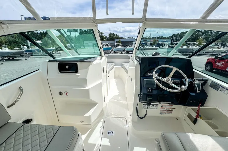  Yacht Photos Pics 2023 Pursuit DC 266 Dual Console boat interior with steering wheel and seating.