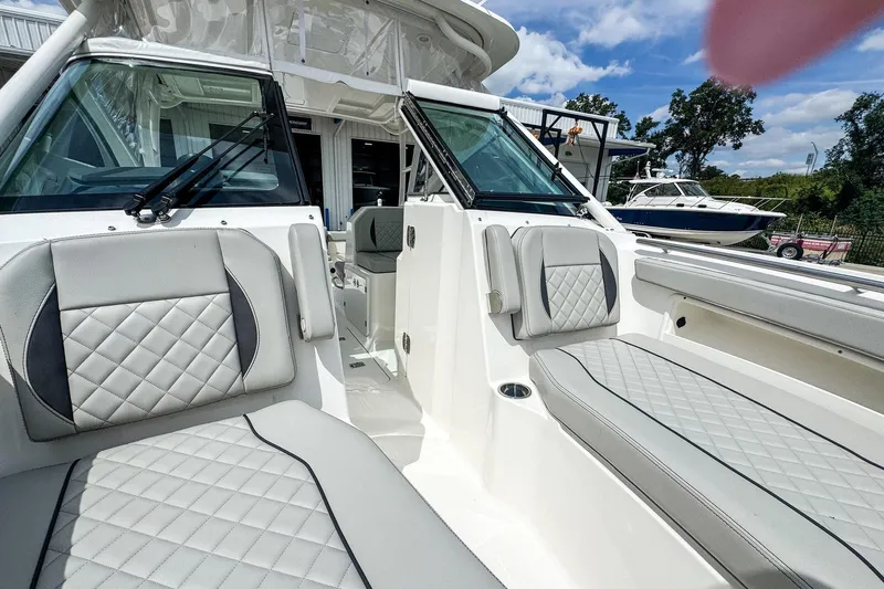  Yacht Photos Pics 2023 Pursuit DC 266 Dual Console boat interior with cushioned seating and windshield.