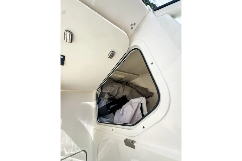  Yacht Photos Pics 2023 Pursuit DC 266 Dual Console storage compartment with gear inside.