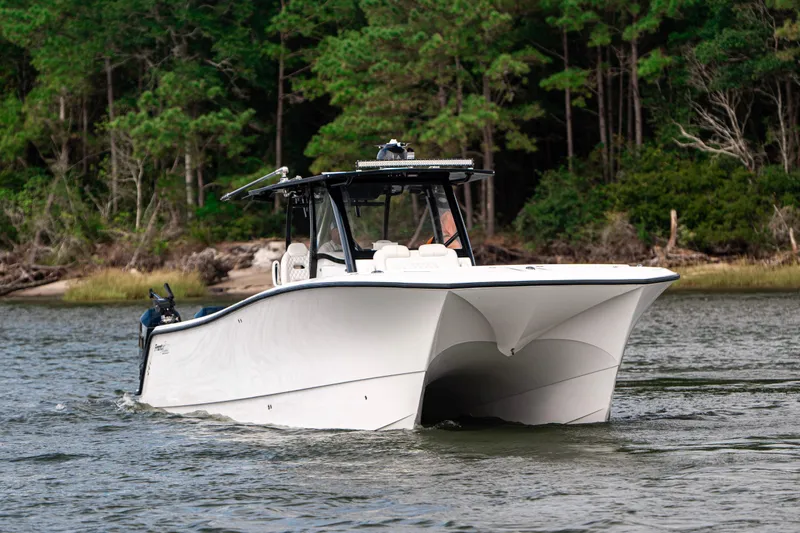  Yacht Photos Pics 2024 Front Runner 37 Catamaran cruising on a scenic river with lush forest backdrop.