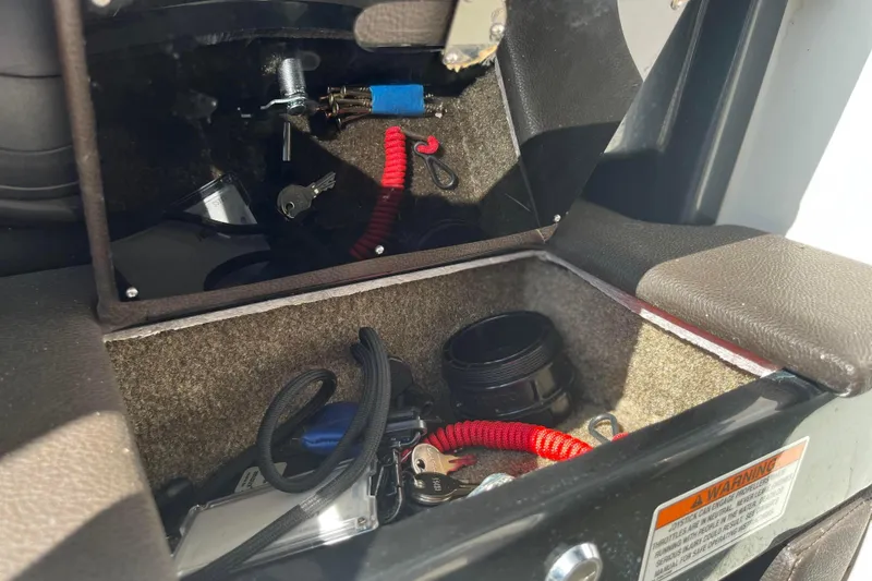  Yacht Photos Pics Storage compartment in a 2018 Sea Ray SLX 350 boat with keys and accessories.