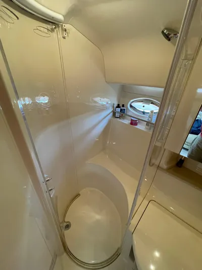  Yacht Photos Pics Bathroom interior of 2000 Sea Ray 460 Sundancer yacht, featuring shower and porthole window.