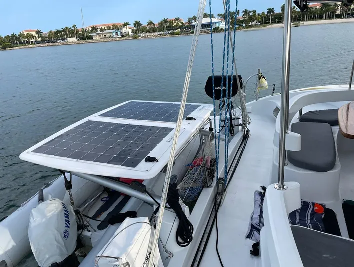  Yacht Photos Pics 2006 Fountaine Pajot LAVEZZI catamaran with solar panels, docked by a calm waterfront.
