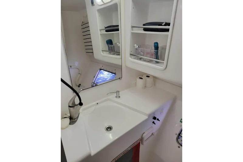  Yacht Photos Pics Bathroom interior of 2006 Fountaine Pajot LAVEZZI catamaran with sink and storage shelves.