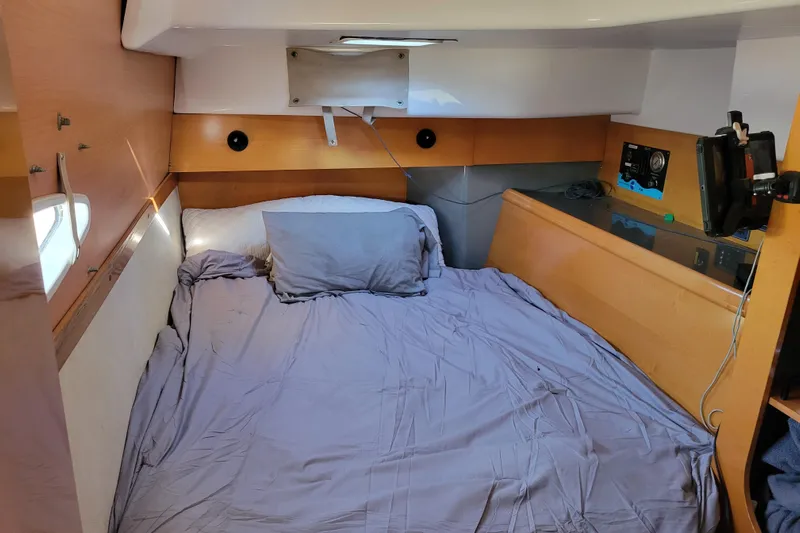  Yacht Photos Pics Cozy cabin interior of 2006 Fountaine Pajot LAVEZZI catamaran with bed and wooden accents.