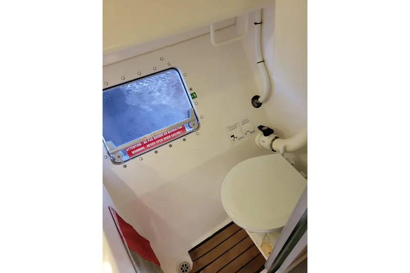  Yacht Photos Pics Bathroom interior of 2006 Fountaine Pajot LAVEZZI catamaran with porthole and toilet.